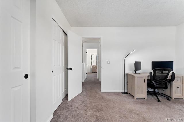 office space with a textured ceiling and light carpet