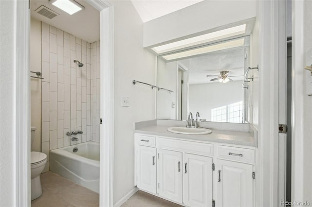 full bathroom with tile patterned floors, vanity, ceiling fan, toilet, and tiled shower / bath