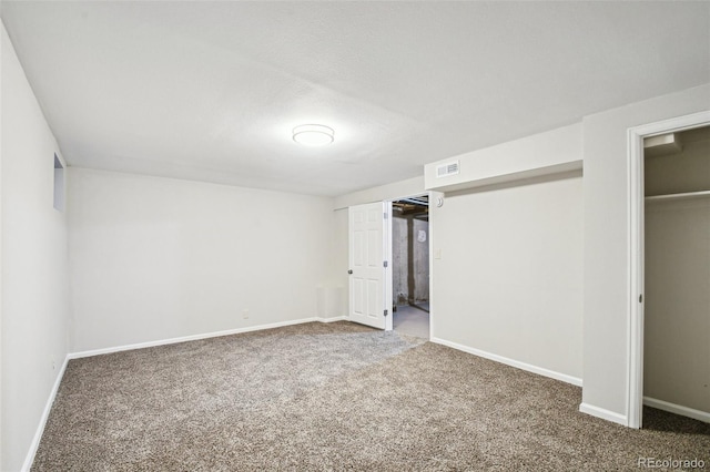 unfurnished bedroom featuring dark carpet and a closet