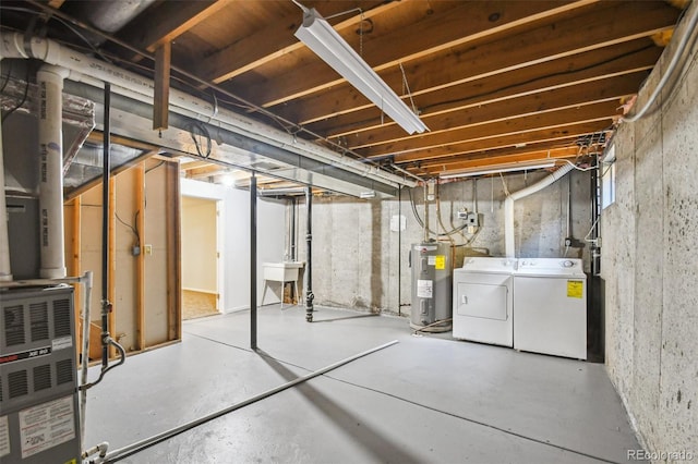 basement featuring washer and dryer, sink, and water heater