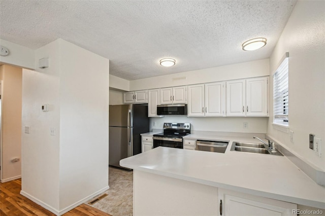 kitchen with sink, kitchen peninsula, light hardwood / wood-style floors, white cabinetry, and stainless steel appliances