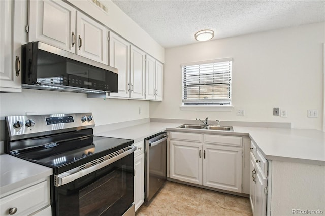 kitchen with white cabinets, sink, appliances with stainless steel finishes, and a textured ceiling