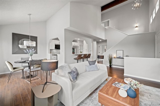 4882 W 68th Ave Unit 4, Westminster, CO 80030 - living area with a chandelier, wood finished floors, high vaulted ceiling, baseboards, and arched walkways