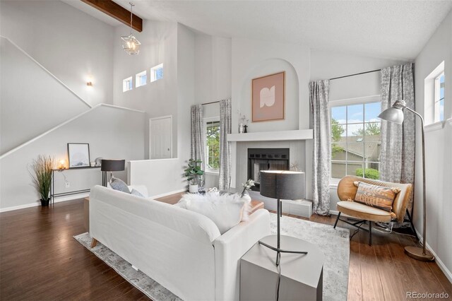 4882 W 68th Ave Unit 4, Westminster, CO 80030 - living room featuring wood finished floors, a fireplace, beamed ceiling, baseboards, and high vaulted ceiling