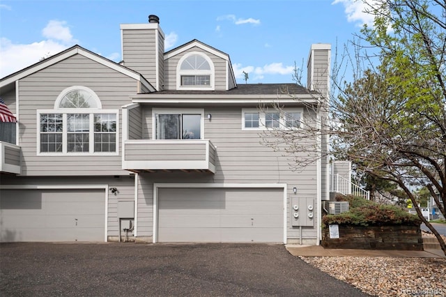 4882 W 68th Ave Unit 4, Westminster, CO 80030 - view of front of home featuring a chimney, an attached garage, and driveway