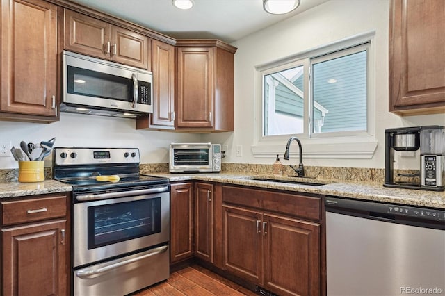 4750 S Dudley St Unit 21, Littleton, CO 80123 - kitchen featuring stainless steel appliances, dark wood-style flooring, and light stone countertops