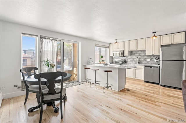 75 N Emerson St Unit 206, Denver, CO 80218 - kitchen with appliances with stainless steel finishes, light wood finished floors, light countertops, backsplash, and a sink