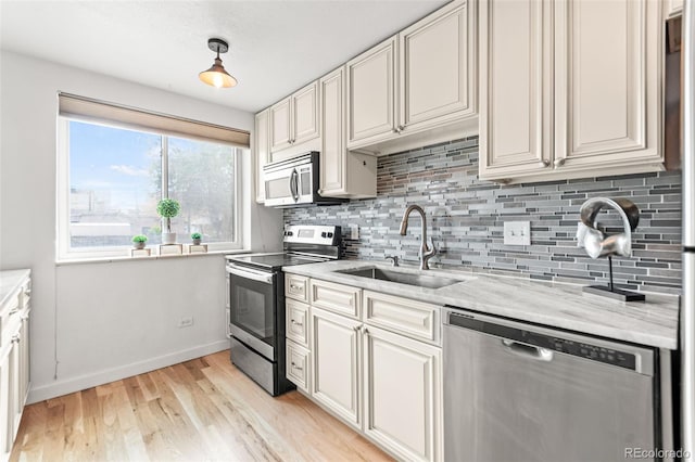 75 N Emerson St Unit 206, Denver, CO 80218 - kitchen featuring appliances with stainless steel finishes, a sink, decorative backsplash, and light wood-type flooring