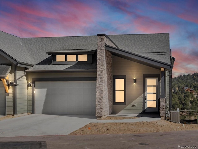 view of front of property with a garage and central AC