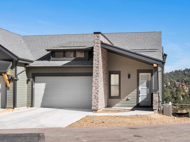 view of front of home with a garage and central AC unit