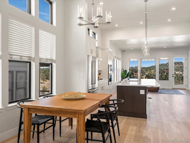 dining space featuring a high ceiling and light wood-type flooring