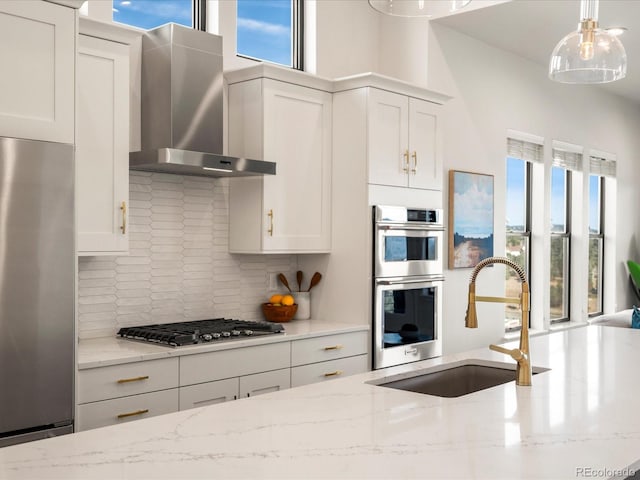 kitchen featuring stainless steel appliances, sink, white cabinets, and wall chimney exhaust hood