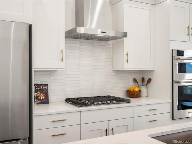 kitchen featuring ventilation hood, white cabinetry, and appliances with stainless steel finishes