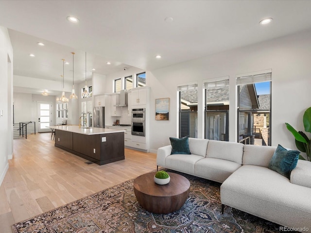 living room with sink and light hardwood / wood-style floors