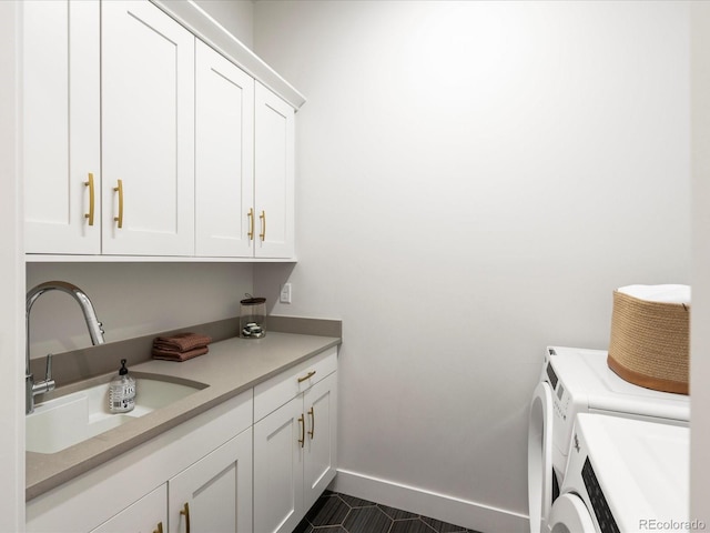 clothes washing area featuring cabinets, washer and dryer, and sink