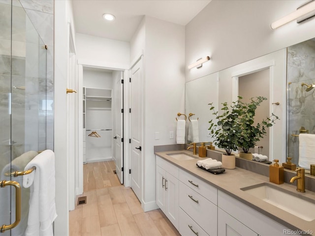 bathroom with hardwood / wood-style flooring, vanity, and walk in shower