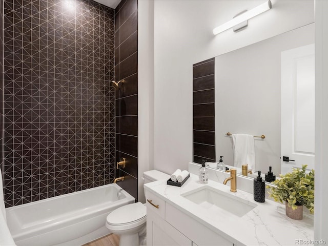 full bathroom with tiled shower / bath, vanity, and toilet