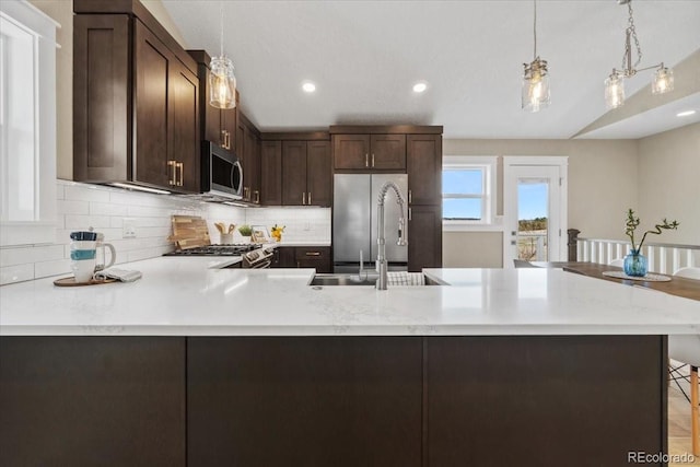 11840 Elkhorn Dr, Franktown, CO 80116 - kitchen featuring a sink, appliances with stainless steel finishes, light countertops, dark brown cabinetry, and tasteful backsplash