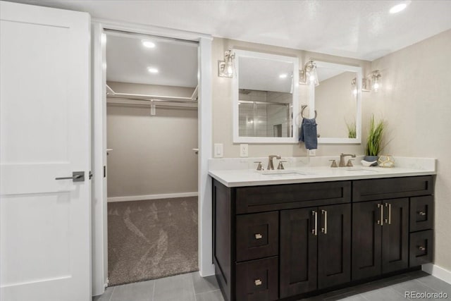 11840 Elkhorn Dr, Franktown, CO 80116 - bathroom featuring double vanity, a spacious closet, a shower stall, baseboards, and recessed lighting