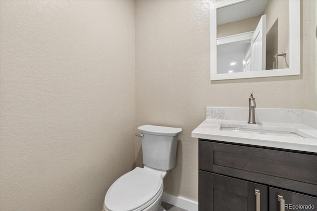 11840 Elkhorn Dr, Franktown, CO 80116 - half bath featuring vanity, toilet, a textured wall, and baseboards