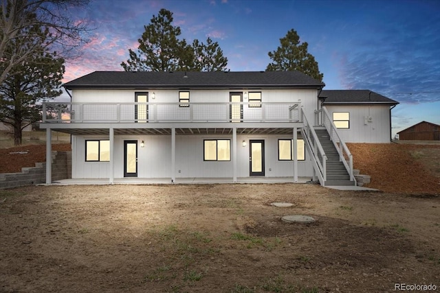11840 Elkhorn Dr, Franktown, CO 80116 - back of house at dusk with stairs and a wooden deck