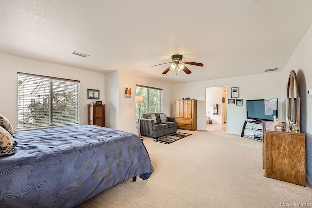 carpeted bedroom with multiple windows and ceiling fan