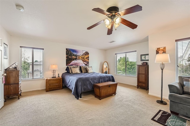 carpeted bedroom featuring ceiling fan and multiple windows