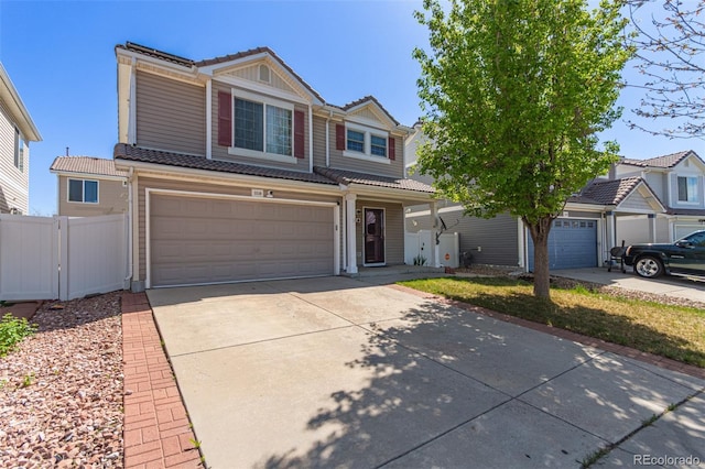 view of front of property featuring a tiled roof, an attached garage, fence, and driveway