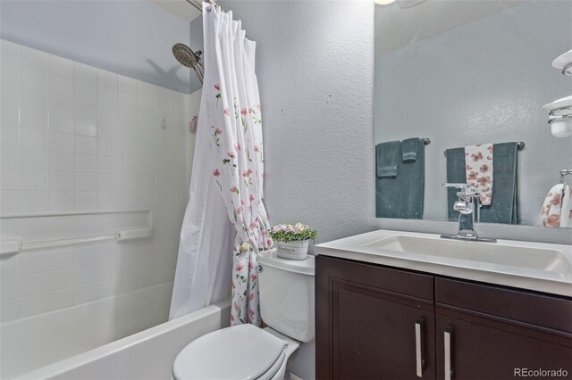 bathroom with vanity, a textured wall, shower / bath combo, and toilet