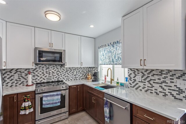 kitchen with light countertops, a sink, decorative backsplash, and stainless steel appliances
