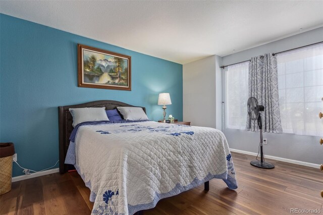 bedroom featuring baseboards and wood finished floors