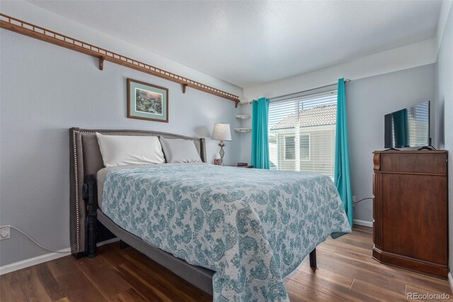 bedroom featuring baseboards and wood finished floors