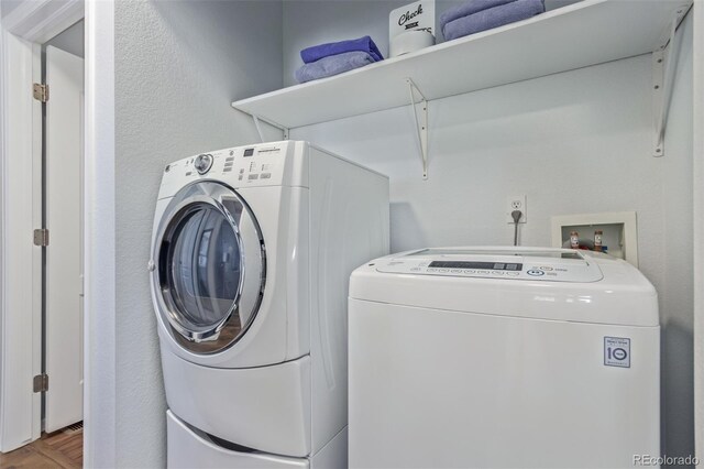 laundry area with laundry area, wood finished floors, and washer and dryer