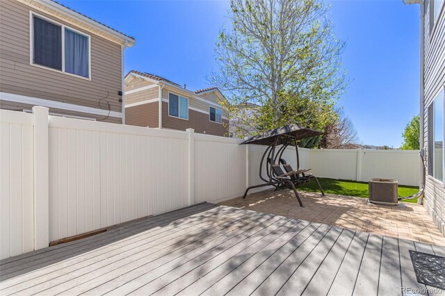 deck featuring a fenced backyard, a patio, and central AC