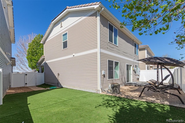 back of house with a fenced backyard, a gate, a patio area, a lawn, and central air condition unit