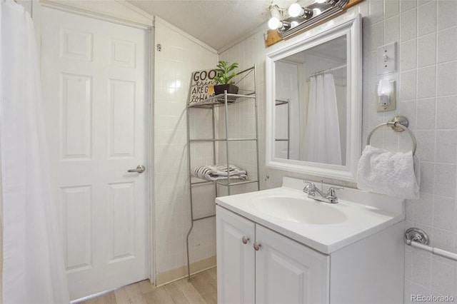 112 S Limit St, Colorado Springs, CO 80905 - bathroom featuring vanity, tile walls, wood finished floors, and lofted ceiling