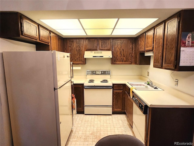 kitchen with white appliances, dark brown cabinetry, and sink