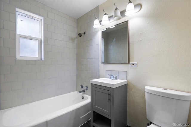 full bathroom with vanity, tiled shower / bath combo, and toilet