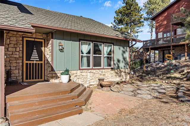 rear view of house featuring a wooden deck