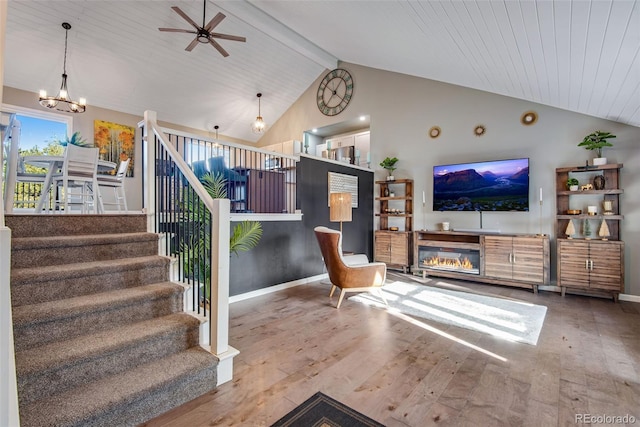 living room featuring hardwood / wood-style floors, ceiling fan with notable chandelier, vaulted ceiling with beams, and wooden ceiling