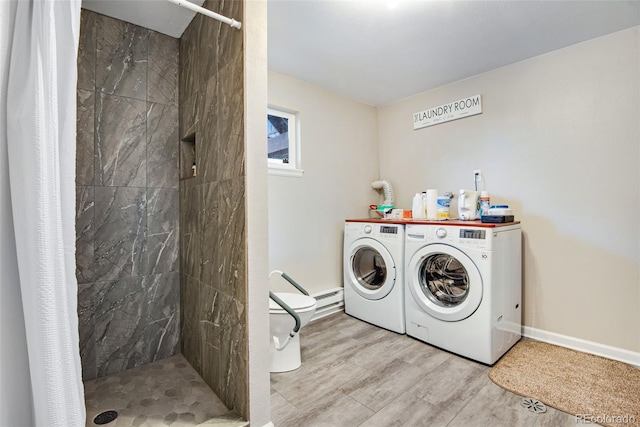 laundry area featuring washing machine and clothes dryer, light hardwood / wood-style floors, and a baseboard heating unit