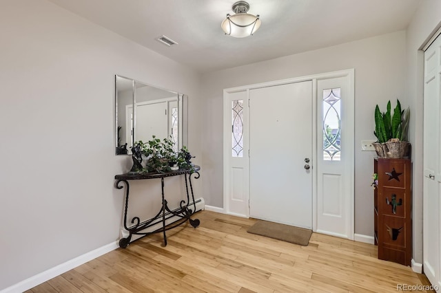 entrance foyer with light wood-type flooring, baseboards, visible vents, and baseboard heating