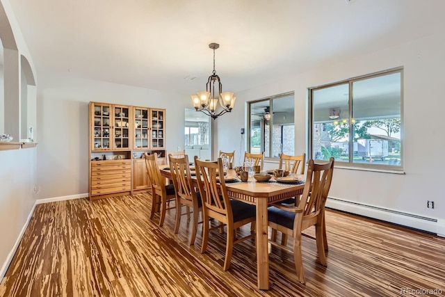 dining area with baseboards, plenty of natural light, baseboard heating, and wood finished floors