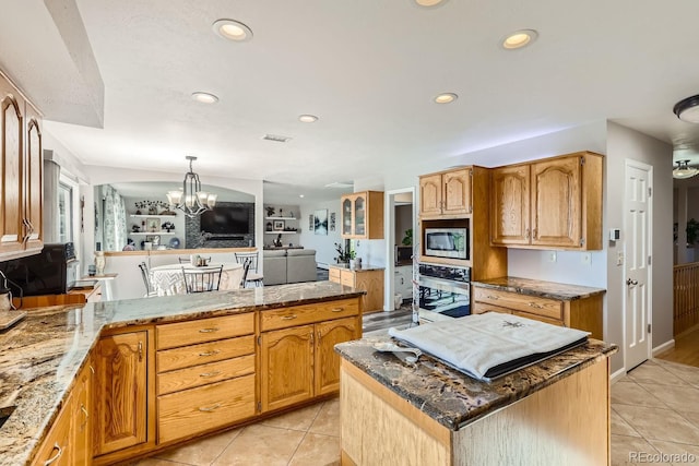 kitchen featuring appliances with stainless steel finishes, dark stone countertops, light tile patterned flooring, and recessed lighting