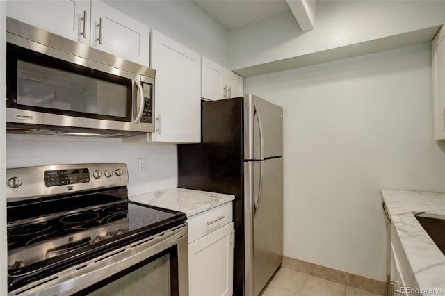 kitchen with light stone counters, backsplash, white cabinetry, appliances with stainless steel finishes, and light tile patterned floors