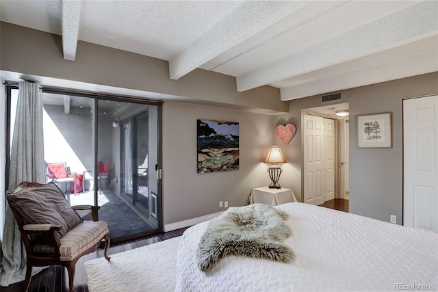 bedroom with visible vents, beamed ceiling, access to outside, a textured ceiling, and wood finished floors