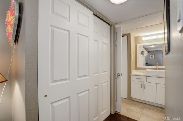 hall featuring light tile patterned floors and a sink