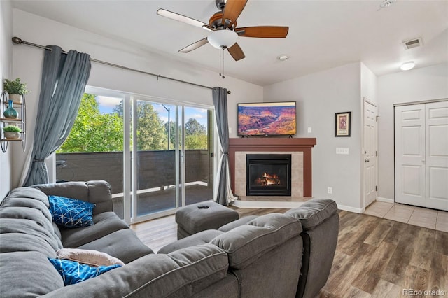 living room with ceiling fan, a fireplace, and hardwood / wood-style floors