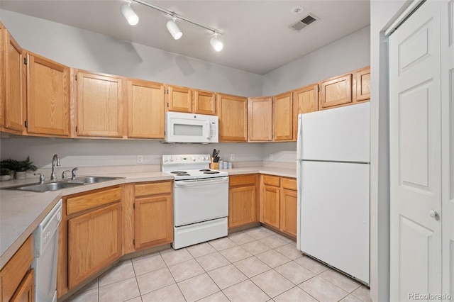 kitchen with white appliances, light brown cabinetry, sink, and light tile patterned floors