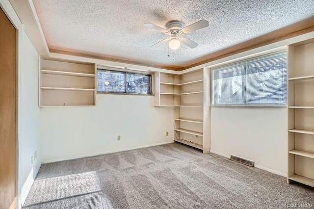 interior space featuring visible vents, a textured ceiling, baseboards, and a ceiling fan